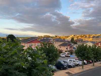a city with cars parked in a parking lot at Apartamento El Puerto in Puerto de Vega