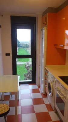a kitchen with a window and a washing machine at Apartamento El Puerto in Puerto de Vega
