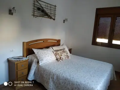 a bedroom with a bed with a wooden headboard at Casa Pura in Ribadeo