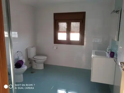 a bathroom with a toilet and a sink and a window at Casa Pura in Ribadeo