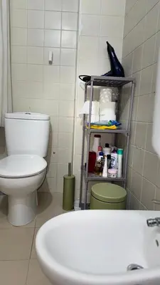 a bathroom with a toilet and a shelf with toiletries at Entire apartment centro ponferrada in Ponferrada