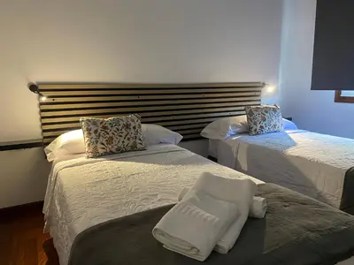 a hotel room with two beds with white sheets at A un Paso in Caldas de Reis
