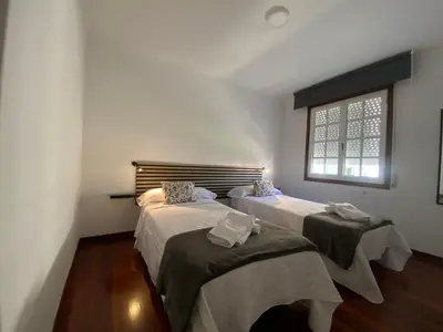 two beds in a room with a window at A un Paso in Caldas de Reis