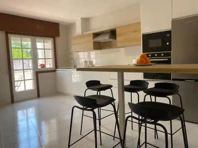 a kitchen with four bar stools and a counter at A un Paso in Caldas de Reis