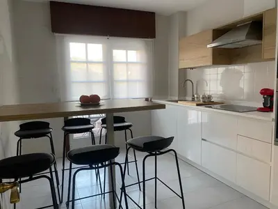 a kitchen with a counter and stools in it at A tres Pasos in Caldas de Reis