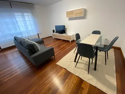 a living room with a couch and a table and chairs at A tres Pasos in Caldas de Reis
