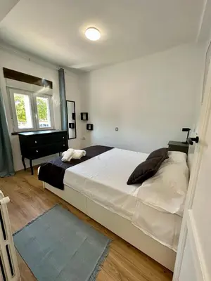 a bedroom with a large white bed and a piano at Alojamientos El Bierzo in Ponferrada