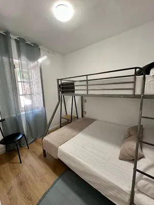 a bedroom with two bunk beds and a chair at Alojamientos El Bierzo in Ponferrada
