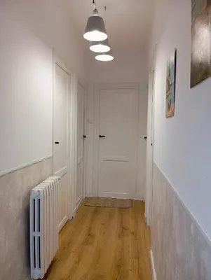 an empty hallway with a white door and a radiator at Alojamientos El Bierzo in Ponferrada
