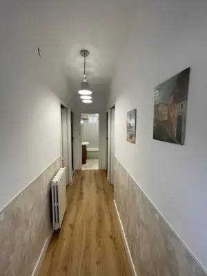 an empty hallway with white walls and wood floors at Alojamientos El Bierzo in Ponferrada