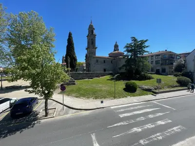 a car parked in front of a building with a clock tower at Destino Allariz in Allariz