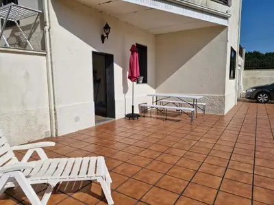 a patio with two chairs and a umbrella on a house at Casa Caldelas in Puente Caldelas