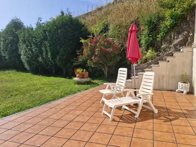 three chairs and an umbrella on a patio at Casa Caldelas in Puente Caldelas
