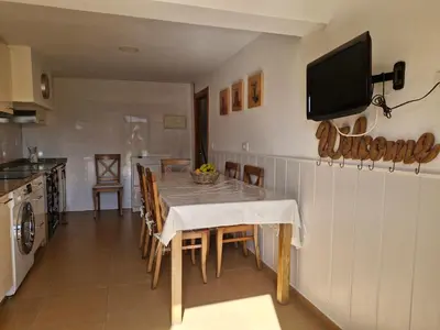 a kitchen and dining room with a table and a television at Casa Caldelas in Puente Caldelas