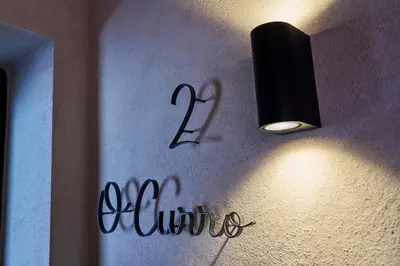 a light hanging on a wall next to a sign at O Campiño Alojamientos Turísticos in Trasmiras