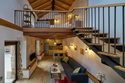 a living room with a couch and a staircase at O Campiño Alojamientos Turísticos in Trasmiras