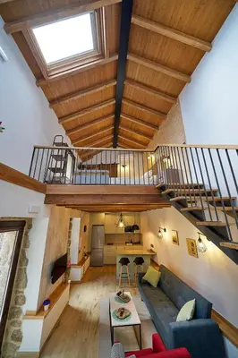 a living room with a couch and a staircase at O Campiño Alojamientos Turísticos in Trasmiras