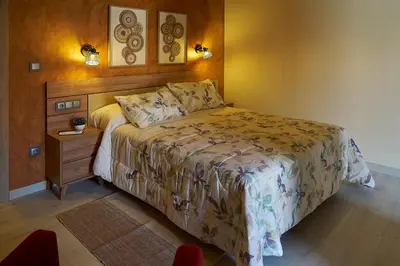 a bedroom with a large bed and a night stand at O Campiño Alojamientos Turísticos in Trasmiras