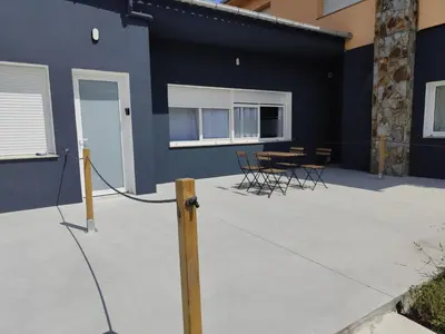 a patio with chairs and a table in front of a building at Lar de Yago - Apto Barreiros B in San Cosme de Barreiros
