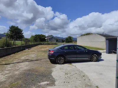 a blue car parked in a parking lot at Lar de Yago - Apto Barreiros B in San Cosme de Barreiros