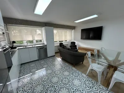 a kitchen and a living room with a table and chairs at Apartamento Fernando III el Santo in Santiago de Compostela