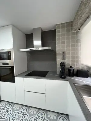 a kitchen with white cabinets and a stove top oven at Apartamento Fernando III el Santo in Santiago de Compostela