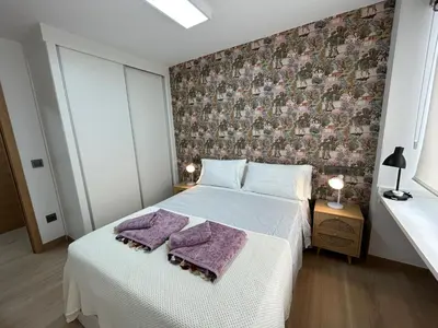a bedroom with a bed with purple towels on it at Apartamento Fernando III el Santo in Santiago de Compostela