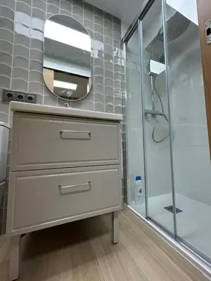 a bathroom with a dresser with a mirror and a shower at Apartamento Fernando III el Santo in Santiago de Compostela