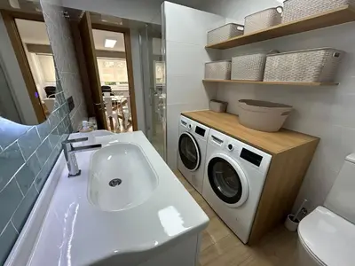 a bathroom with a sink and a washing machine at Apartamento Fernando III el Santo in Santiago de Compostela
