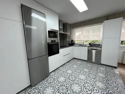 a kitchen with stainless steel appliances and a tile floor at Apartamento Fernando III el Santo in Santiago de Compostela
