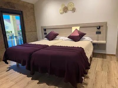 a bedroom with a large bed with purple sheets at A Casa do Pillado in Vilariño