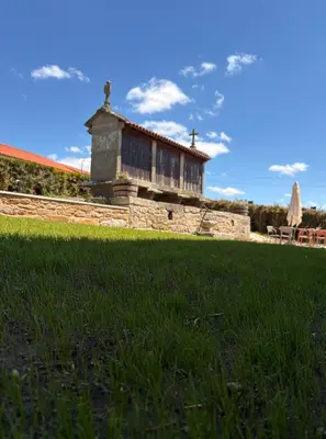 a building in a yard with a grass field at A Casa do Pillado in Vilariño