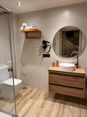 a bathroom with a sink and a toilet and a mirror at A Casa do Pillado in Vilariño