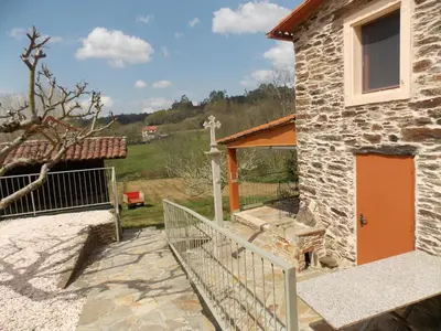 a stone building with a cross on the side of it at Granja del Peregrino in O Pino