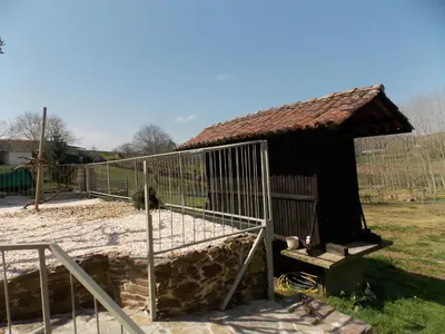 a small building in a field with a fence at Granja del Peregrino in O Pino