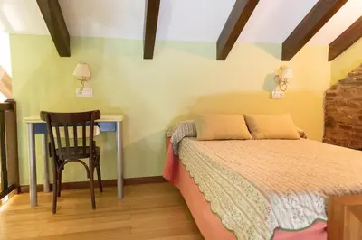 a bedroom with a bed and a chair and a desk at Apartamentos Turisticos A Estacion in A Pontenova