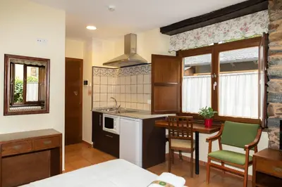 a kitchen with a table and chairs in a room at Apartamentos Turisticos A Estacion in A Pontenova