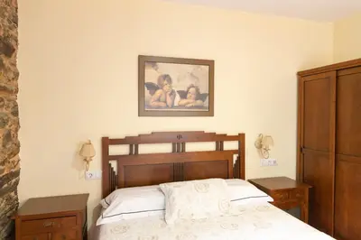 a bedroom with a bed and a picture on the wall at Apartamentos Turisticos A Estacion in A Pontenova