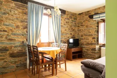 a dining room with a table and chairs and a tv at Apartamentos Turisticos A Estacion in A Pontenova