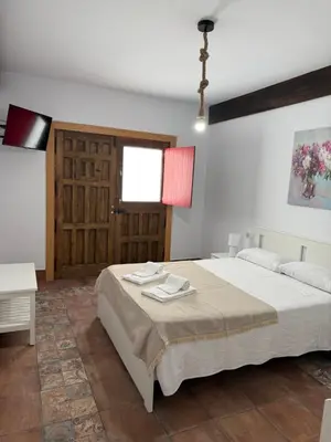 a bedroom with a bed and a table and a window at Primavera in Padrón