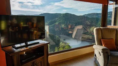 a living room with a tv and a large window at Casa El Mirador del Miño en la Ribeira Sacra in Rosende