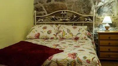 a bedroom with a bed and a lamp on a dresser at Casa El Mirador del Miño en la Ribeira Sacra in Rosende