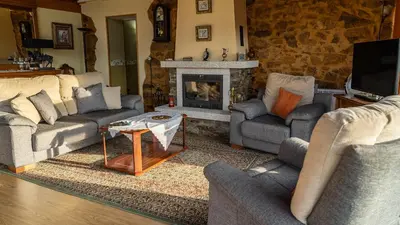 a living room with two couches and a fireplace at Casa El Mirador del Miño en la Ribeira Sacra in Rosende
