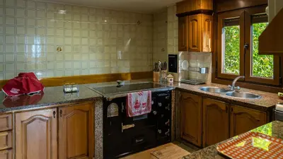 a kitchen with a sink and a black dishwasher at Casa El Mirador del Miño en la Ribeira Sacra in Rosende