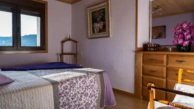 a bedroom with a bed and a dresser and a window at Casa El Mirador del Miño en la Ribeira Sacra in Rosende