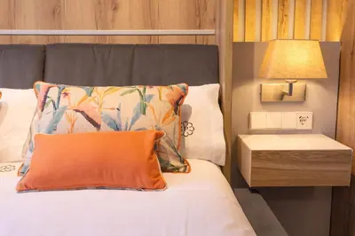 a bedroom with a bed with an orange pillow and a lamp at Albariño in Pincelo
