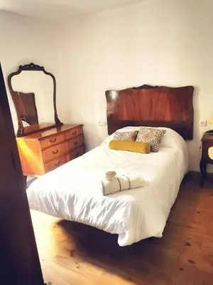 a bedroom with a bed with a dresser and a mirror at Apartamento MIZA in Ponferrada