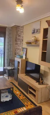 a living room with a television and a table at La Vega De Somiedo in Pola de Somiedo