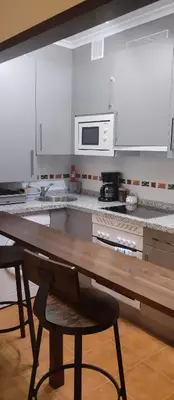 a kitchen with a wooden table and a microwave at La Vega De Somiedo in Pola de Somiedo