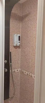 a tiled bathroom with a shower with a toaster at La Vega De Somiedo in Pola de Somiedo